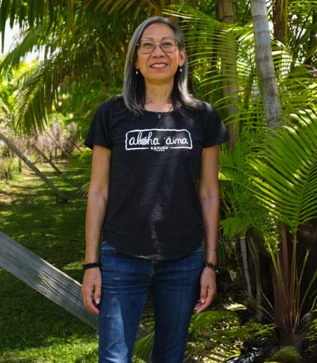 Tessa Ahsing of Savor Brands standing among palms on a Hawaii farm
