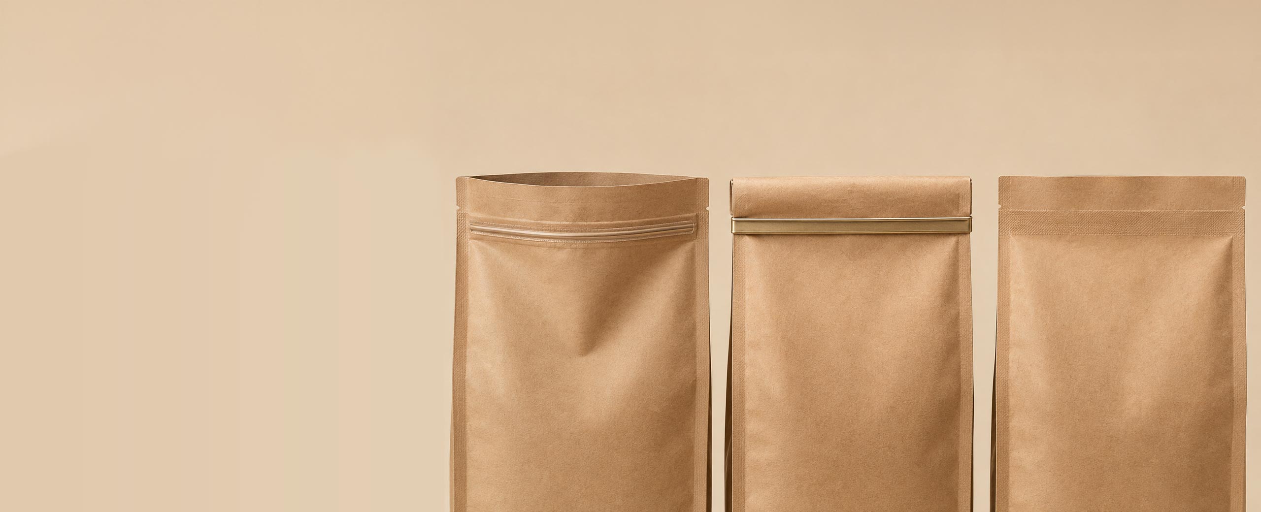Three coffee bags side by side showing a press to seal zipper, a tin tie, and a plain heat sealed top