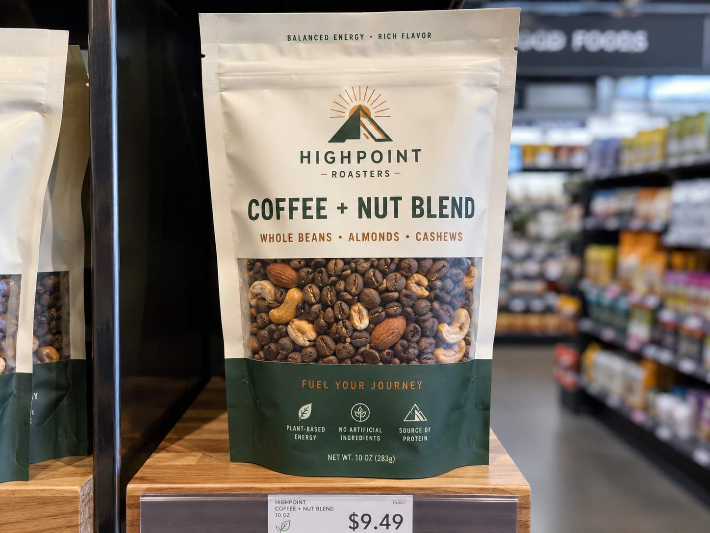 A windowed coffee and food pouch under bright store lighting with whole coffee beans and nuts visible through the clear panel, showing the light-exposure trade-off