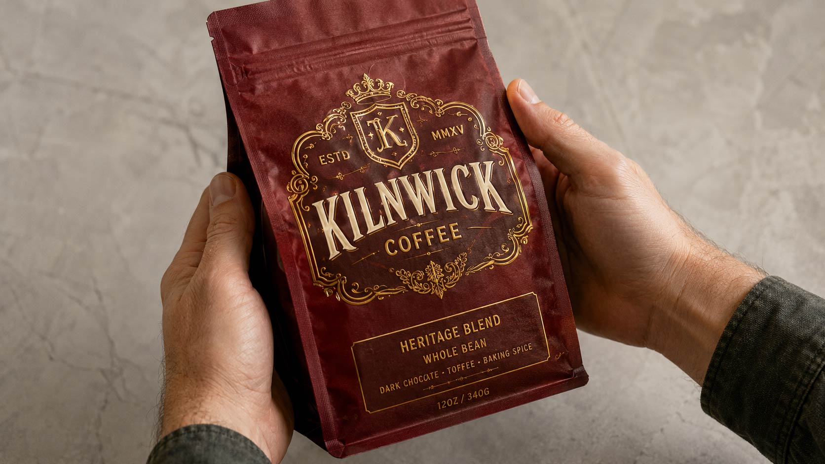 Close-up of two hands holding a printed coffee bag sample under neutral light, checking the printed brand color and the texture of the bag material