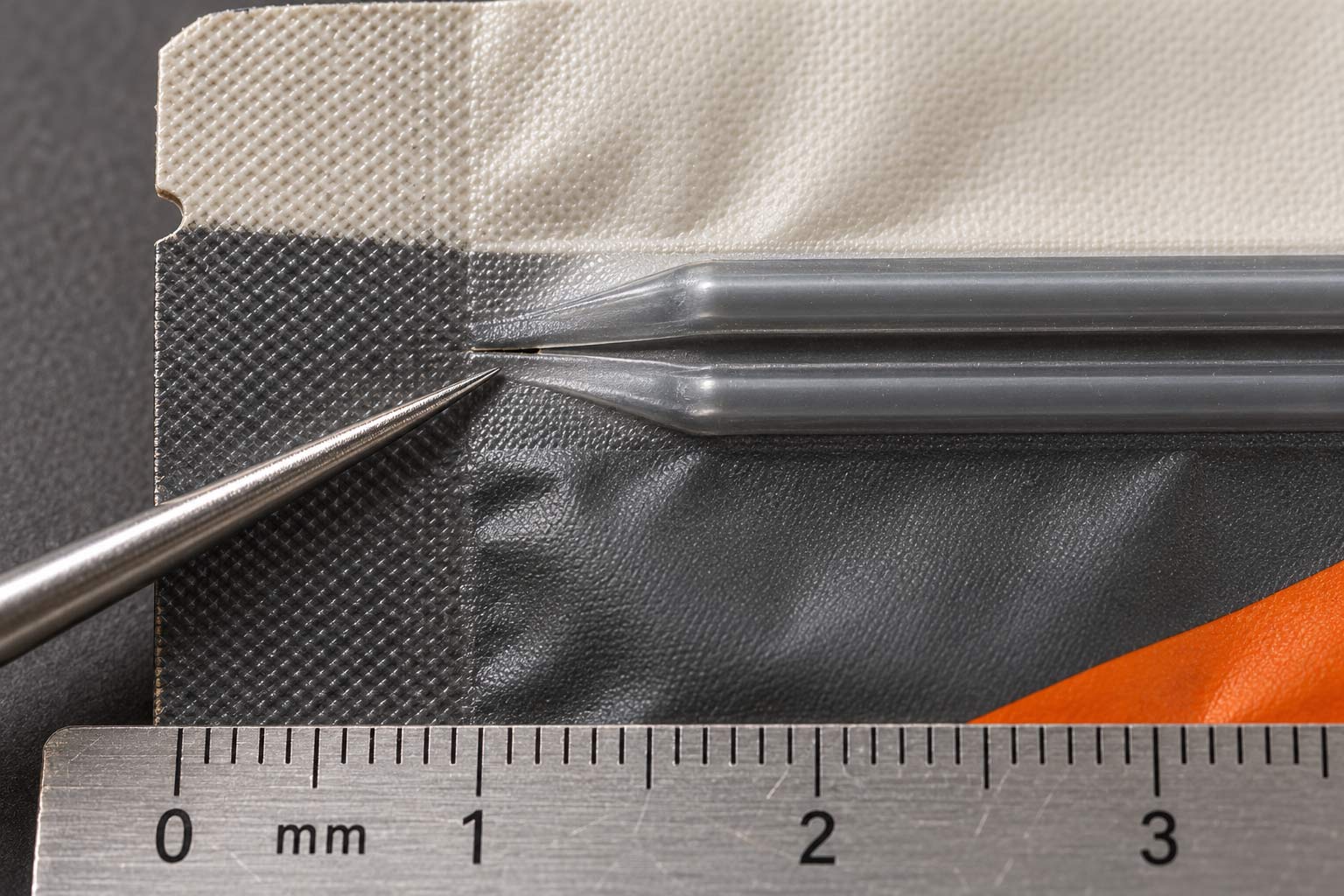Macro view of a coffee bag zipper end, showing the full zipper profile flattening into the side seal and a small gap at the corner