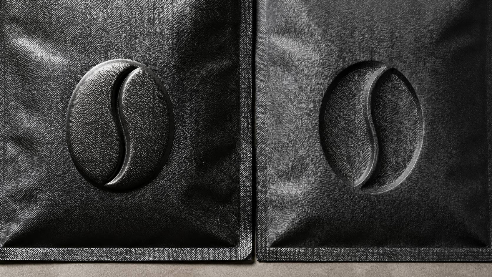 Macro comparison of a raised embossed shape beside a recessed debossed shape on coffee bag material