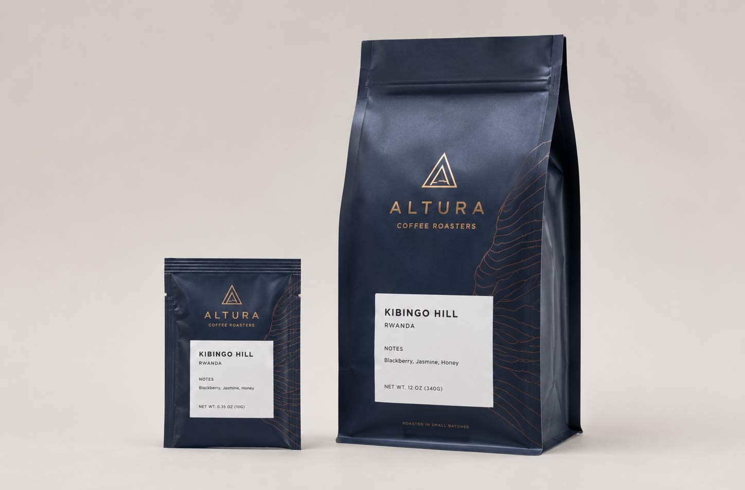 A small flat tri-seal coffee sample pouch next to a full-size stand-up coffee bag from the same brand, showing the clear size difference